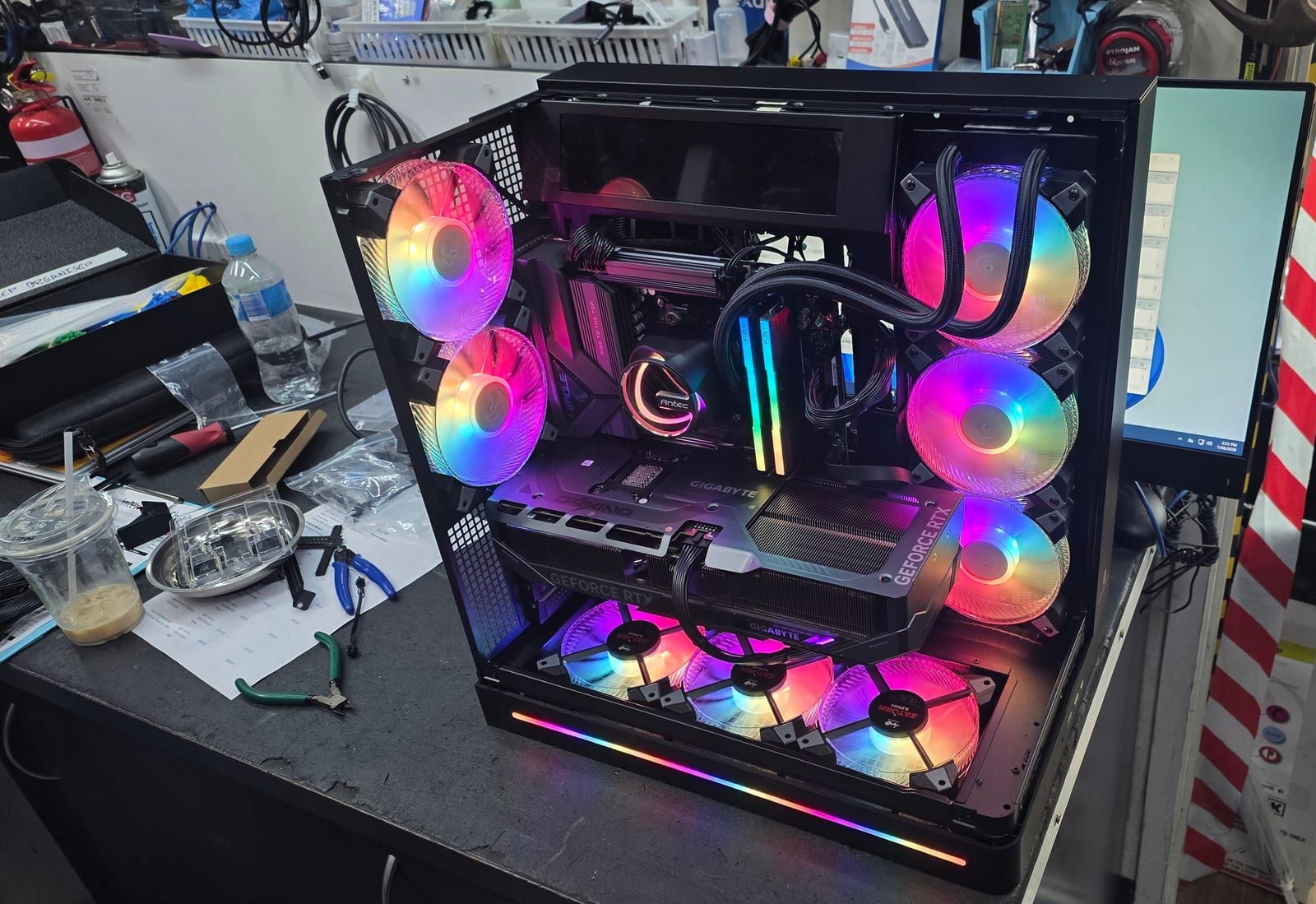 The same black PC case from a front angle, RGB fans lit purple and blue