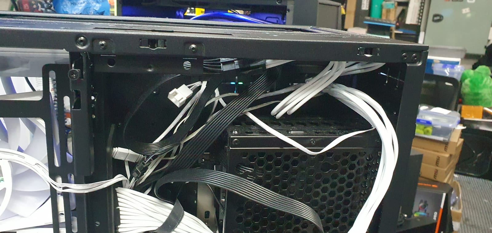The inside of a PC case mid-build with dozens of unrouted cables tangled together with no colour grouping