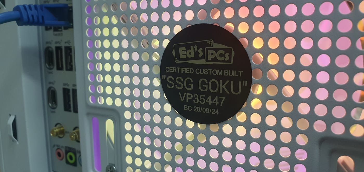 An engraved black Ed’s PCs plate reading CERTIFIED CUSTOM BUILT, "SSG GOKU", on the perforated rear panel of a white PC case