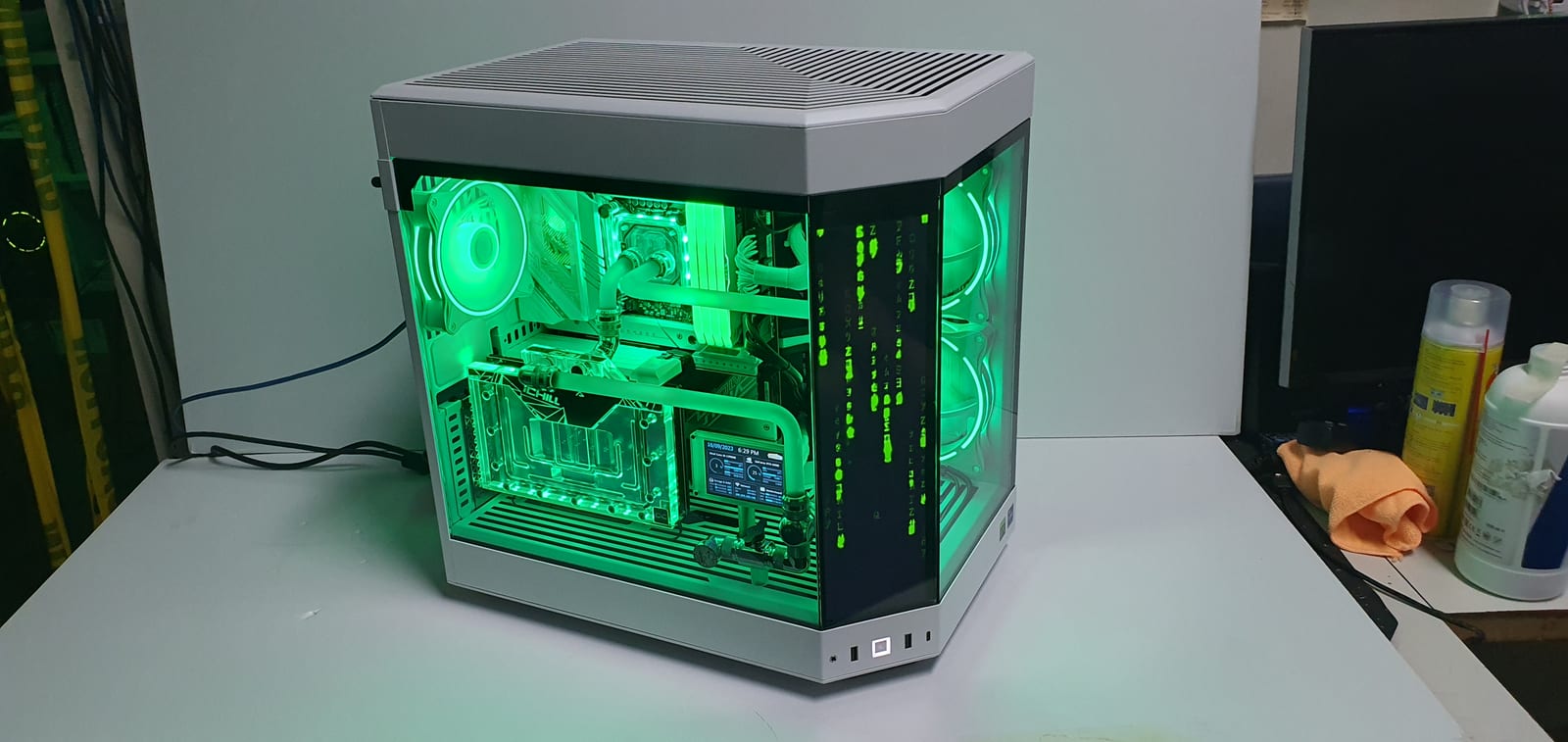 The same build with the front screen showing green falling-code animation and the interior lit to match