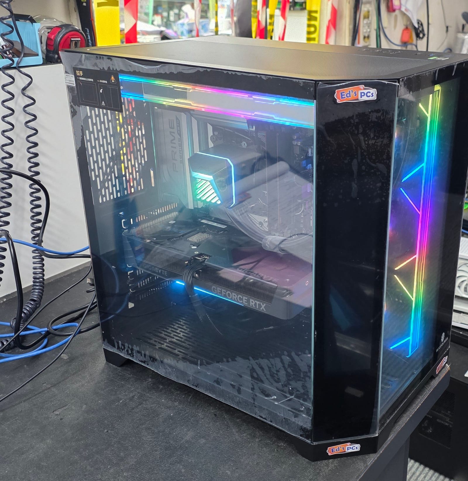 A black PC case with wrap-around glass and a lightning-bolt RGB strip running down the front corner