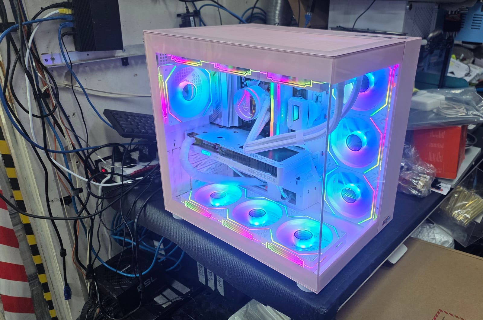 The same pink case from a front angle, nine fans lit in a rainbow profile