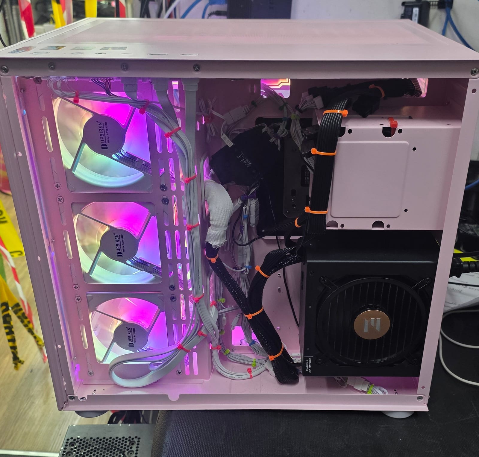 The rear of the pink case with white-sleeved cables routed and zip-tied behind the tray