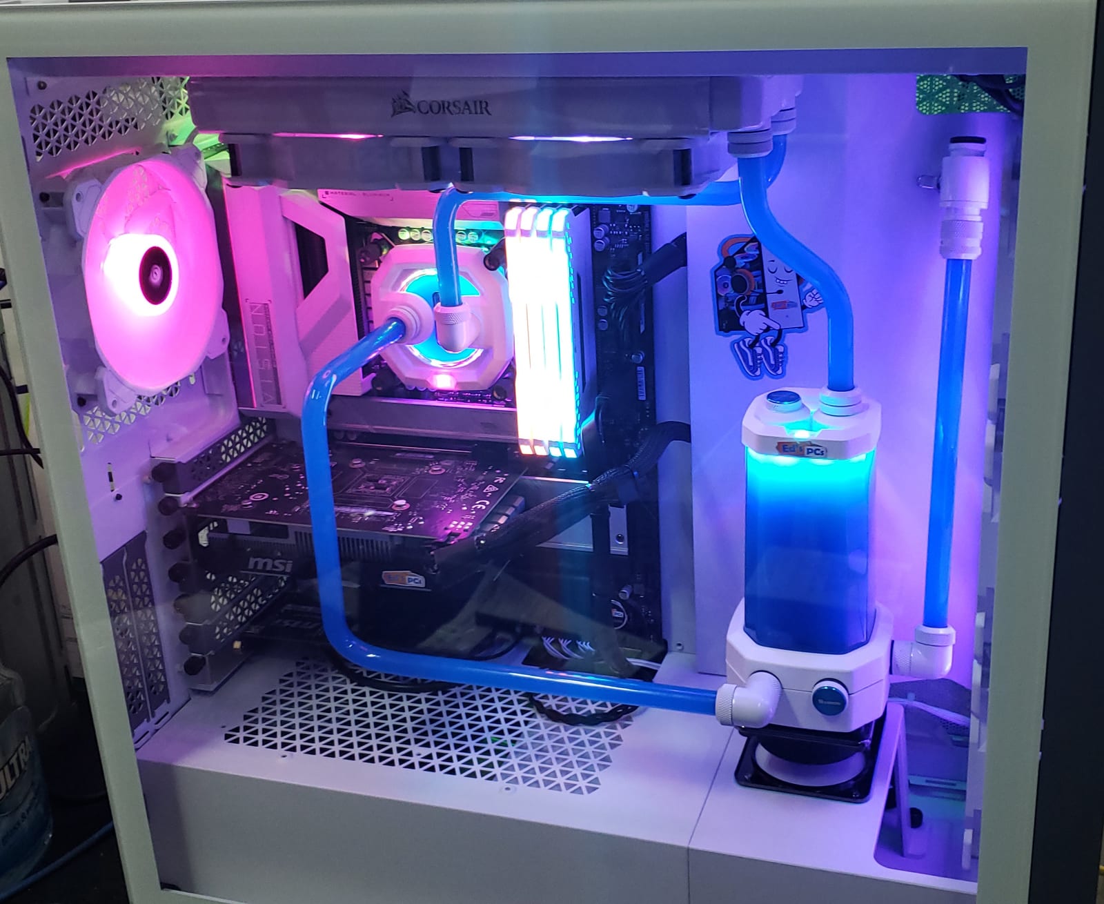 The same white hard-line build lit blue and purple instead of teal, showing the full loop from the CPU block round to the reservoir
