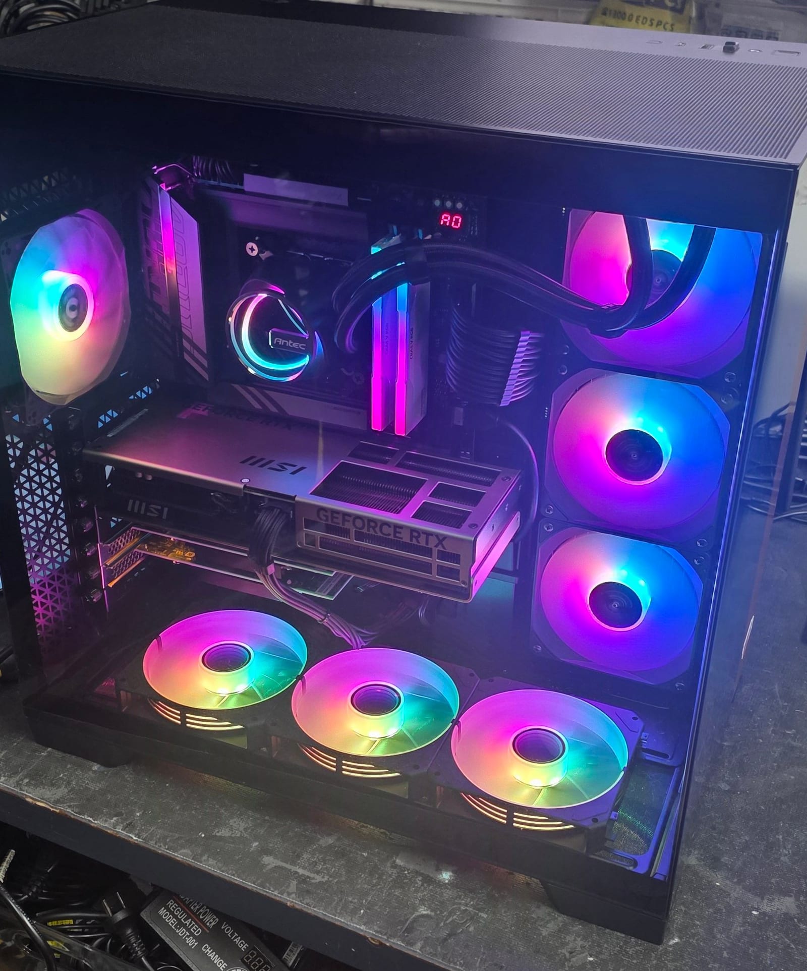A black PC case with glass front and eight RGB fans lit purple and blue