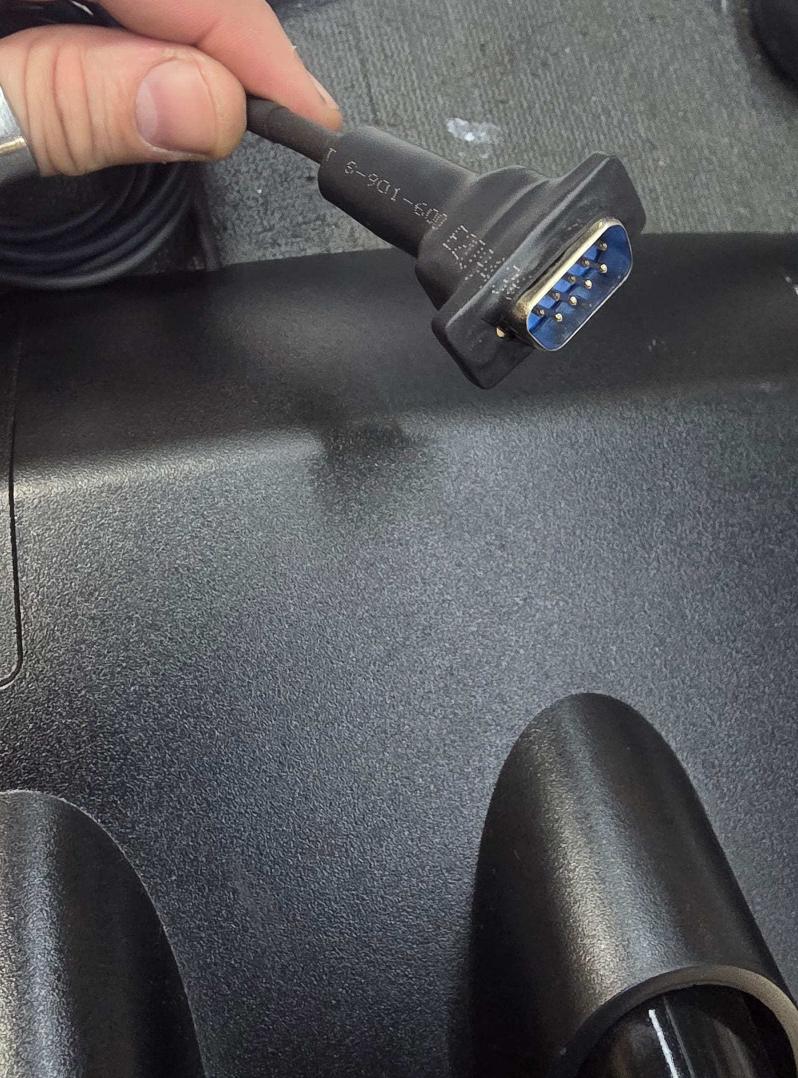 A rebuilt data cable plug held in hand, the new connector overmoulded so it looks factory-made