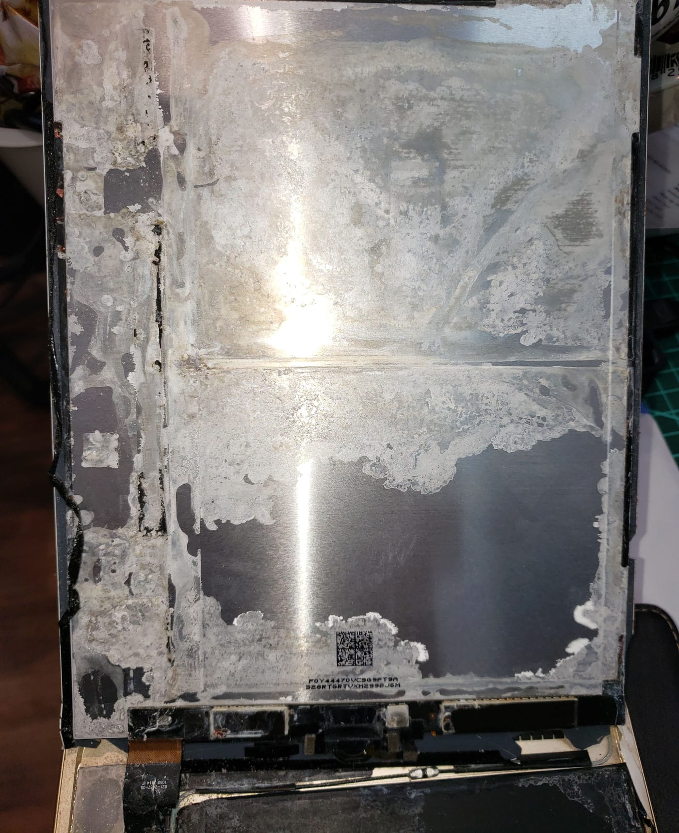 The inside of a liquid-damaged tablet, its metal shielding covered in heavy white corrosion