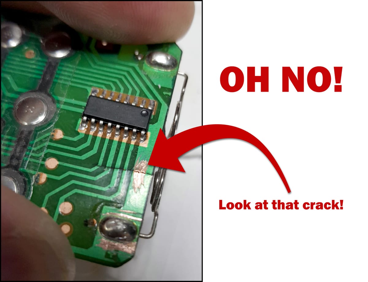 Macro photo of a remote control circuit board with a crack running through its copper tracks, annotated OH NO, look at that crack