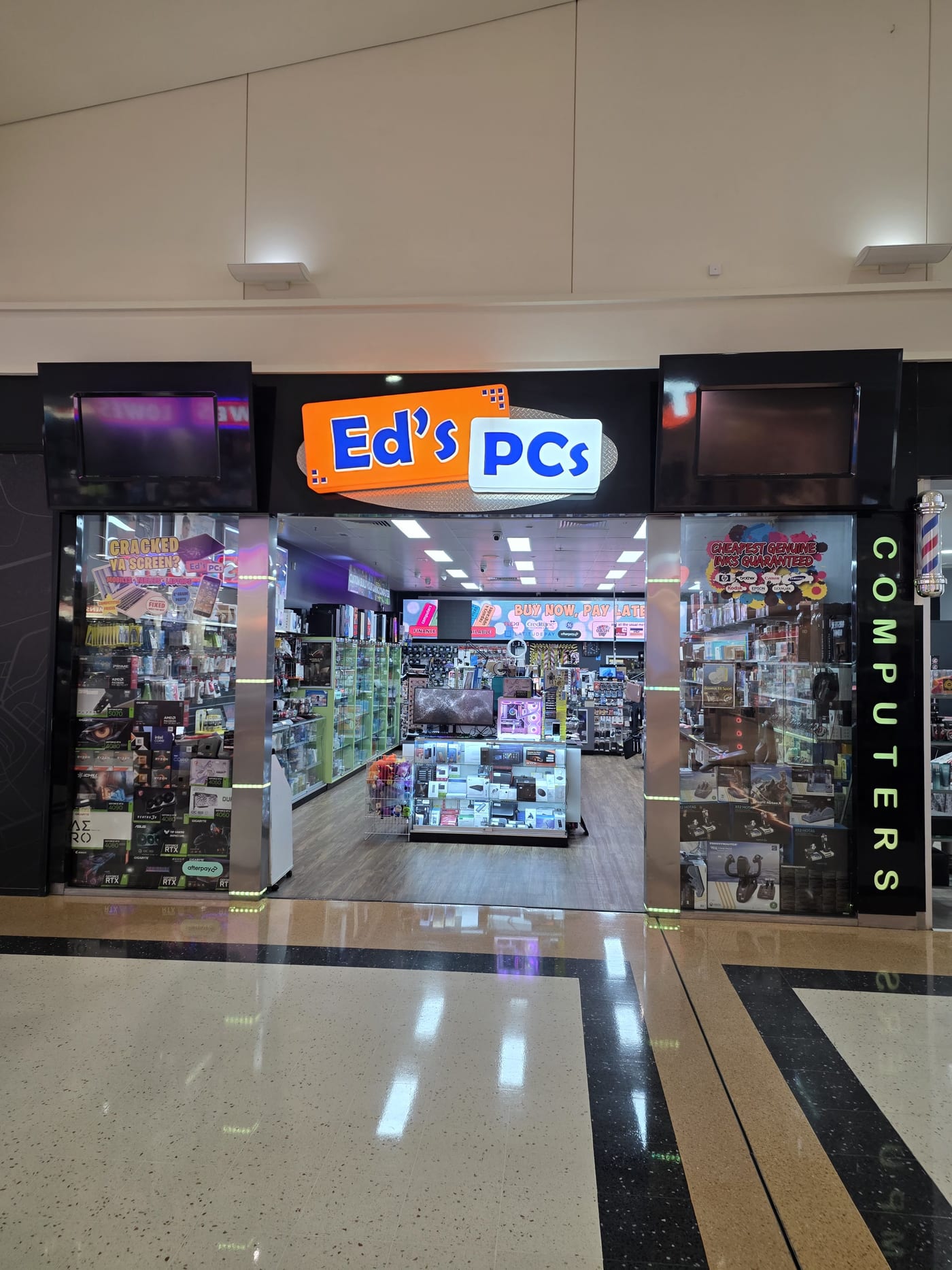 The Ed's PCs shopfront at Victoria Point Shopping Centre, illuminated sign above an open entrance, graphics cards and accessories filling the window displays